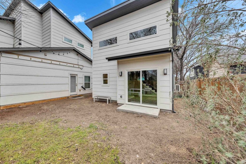 Modern backyard with white siding house