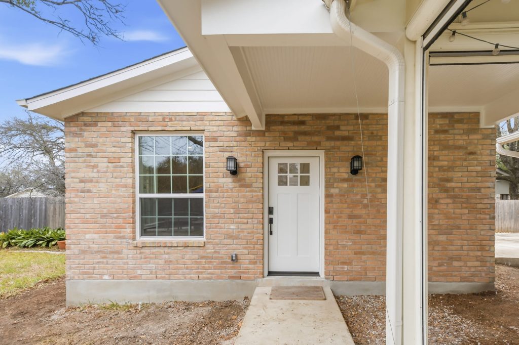 Brick house entrance with white front door
